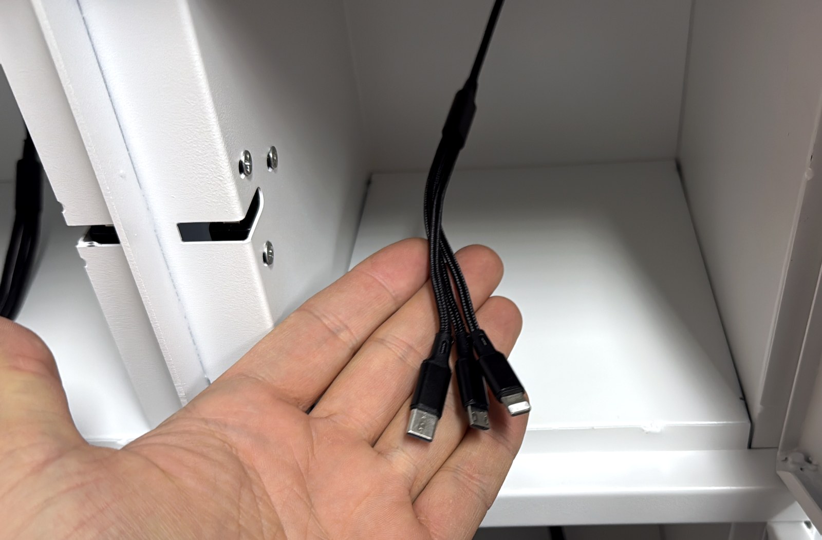 Kabel do ładowania 3 w 1 w skrytce: USB-C, Lightning i micro-USB